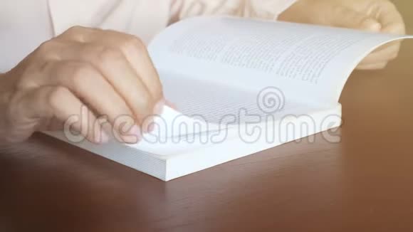4K女性阅读教科书用手翻动每一页从木桌上的纸角上阳光从窗户照射出来视频的预览图