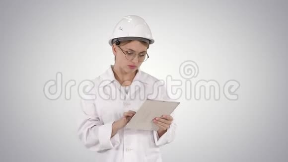 优雅体贴的年轻工程师与她的平板电脑在梯度背景下工作视频的预览图