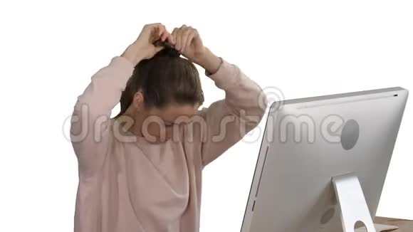 办公室女士穿着粉红色套头衫有一根马尾辫在白色背景下电脑上工作视频的预览图