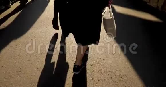 穿着靴子和运动鞋在街上行走的女人视频的预览图