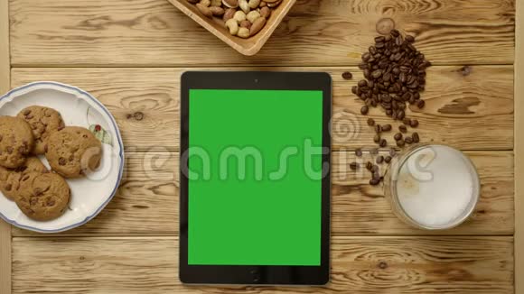 带绿屏平板电脑咖啡杯咖啡豆饼干和坚果的日落时间视频的预览图