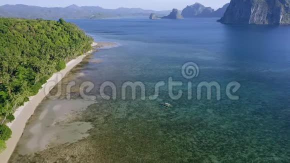 菲律宾巴拉望ElNido的空中景观班卡船在浅水中游向孤独的热带海滩视频的预览图