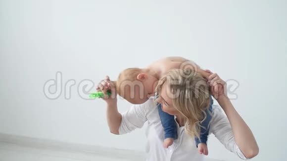 童年母亲和家庭的概念幸福的母亲把孩子抱在白色的背景上视频的预览图