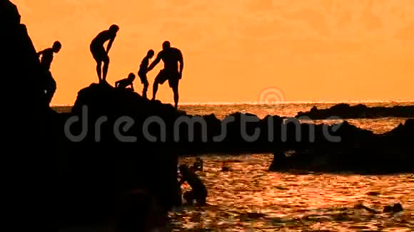 日落时孩子们跳进水里夏威夷的威美亚海滩视频的预览图