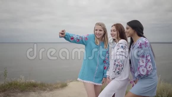 三个女朋友穿着夏天的长时装在湖或河的背景两个高加索人视频的预览图
