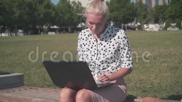商务女性穿着白色衬衫带着豆在笔记本电脑后面工作她累了把工作留给远方视频的预览图