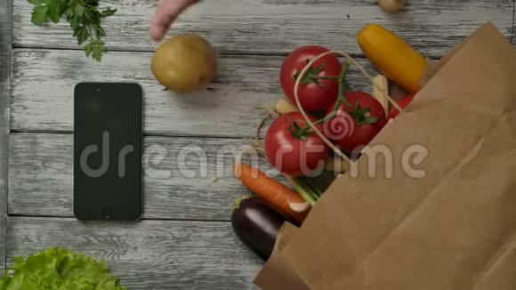 在智能手机和杂货店附近旋转的土豆水果视频的预览图