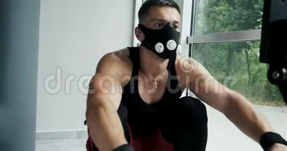强壮的肌肉男在室内划船模拟器上工作健身房交叉健身训练视频的预览图