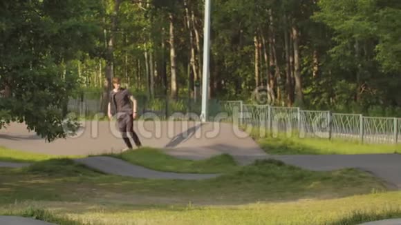 青年男子在绿色公园的特殊波浪路上滑板滑板视频的预览图