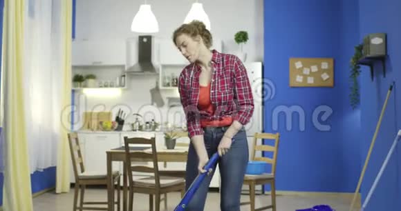 年轻女子在厨房打扫卫生听音乐视频的预览图