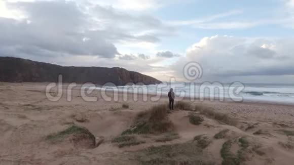 孤独的男人在寒冷的冬季海滩上视频的预览图