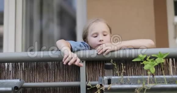 一个可爱的女孩坐在阳台上视频的预览图