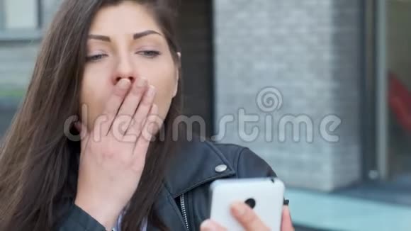 心烦意乱的女人看着一部智能手机显示出他破碎的屏幕视频的预览图