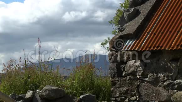 一座古老的石仓在山上有一个铁皮屋顶视频的预览图