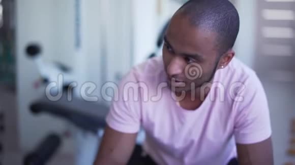 男的在健身房说话一个穿白色T恤的非裔美国人在健身房健身治疗的肖像视频的预览图