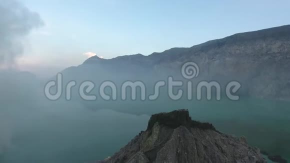 空中拍摄的蓝色湖泊上面有蒸汽在山上4k视频的预览图