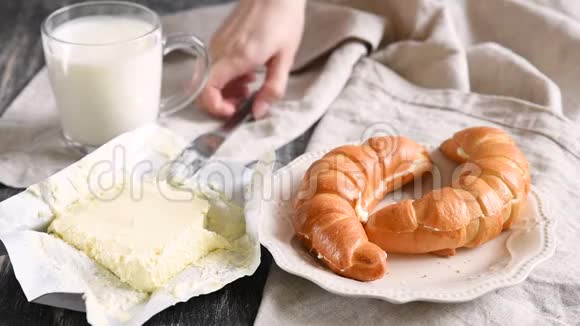 女人把黄油涂在新鲜牛角面包上欧式早餐视频的预览图