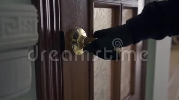 穿着黑色衣服和手套的人开门小偷闯进了房子违法犯罪视频的预览图