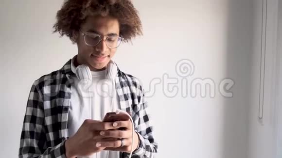 英俊的非裔美国人在家里用他的手机孤立于白色背景视频的预览图