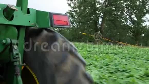 一辆现代农用拖拉机的后轮胎在行驶时从后面旋转视频的预览图