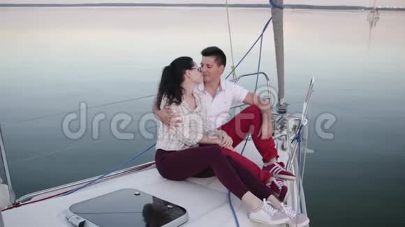 可爱的一对情侣在帆船甲板上互相欣赏日落视频的预览图