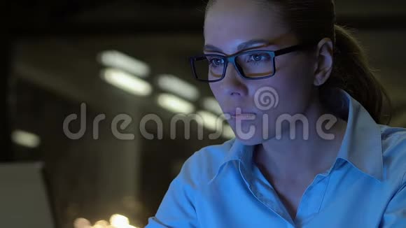 漂亮的商务女士戴着眼镜在夜间特写时打字加班视频的预览图