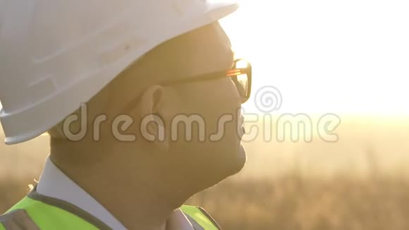 戴着眼镜和头盔的亚洲工程师在阳光下欣赏着所做的工作视频的预览图