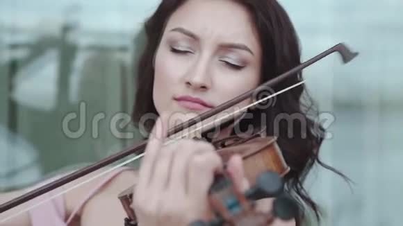热情的女人在大楼里热情地拉小提琴视频的预览图