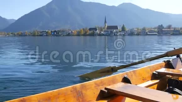 一个坐在木船上的渡船人用桨把人们带到另一边背景是美丽的风景如画视频的预览图