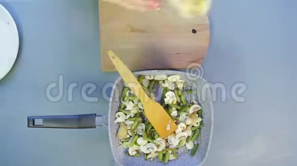 一个女人把豆子和蘑菇混合在平底锅里烤切鸡胸时光飞逝视频的预览图