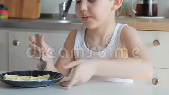 男孩在厨房里吃煎蛋卷红猫跟在他后面走视频的预览图