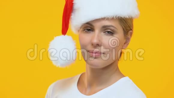 穿着圣诞老人帽子的调情女士送空气亲吻到相机节日娱乐视频的预览图