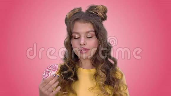 漂亮造型的迷人女孩吃甜甜圈享受美味视频的预览图