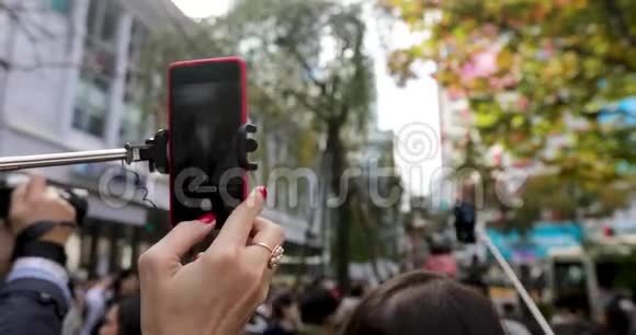 街头自拍杆上的智能手机拍摄者视频的预览图