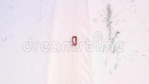 一辆车正沿着一条冬天下雪的乡村道路行驶从无人驾驶飞机上俯瞰视频的预览图