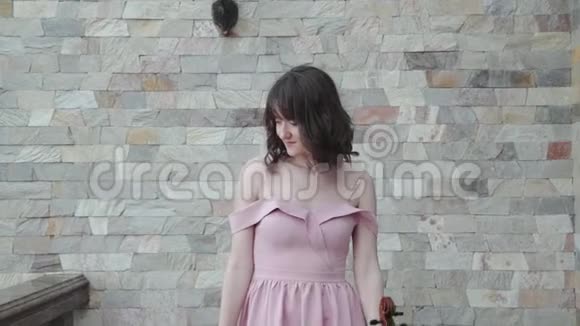 自信的女人走在阳台上玩中提琴在镜头前转视频的预览图