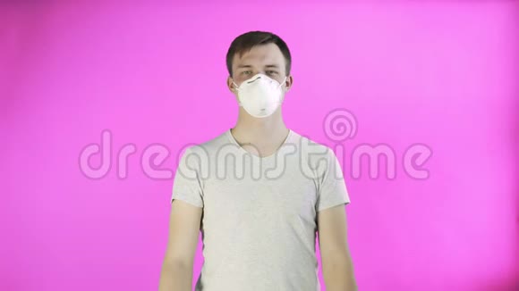 青年活动家脸上戴面具并在粉红色背景下张贴帮助海报视频的预览图