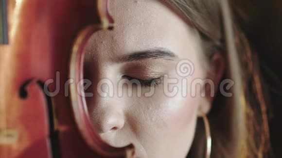 神秘的女孩睁开眼睛用小提琴看着镜头的一部分脸视频的预览图
