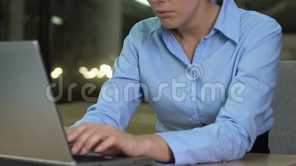 女性工作狂打哈欠打手提电脑键盘深夜工作最后期限视频的预览图