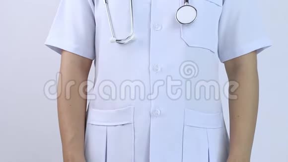 年轻的女医生穿着白色外套双手插在白色背景上的口袋里视频的预览图