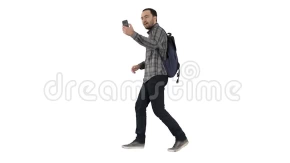 年轻快乐的微笑男子背包记录vlog博客与他的手机在白色背景视频的预览图