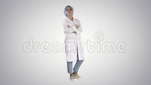 微笑自信的年轻女医生站着手臂交叉在梯度背景上视频的预览图