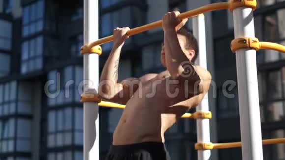肌肉男在水平杆上做拉力家附近的健身区视频的预览图