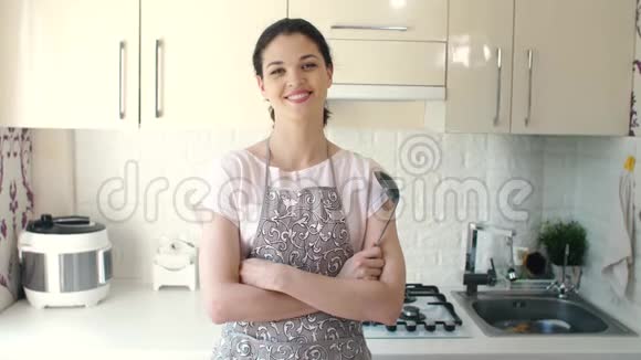 现代厨房中微笑的年轻家庭主妇画像视频的预览图