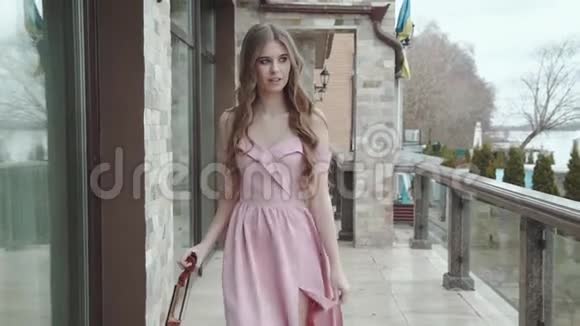 穿着小提琴的热情女孩在手中行走在镜头前转身视频的预览图