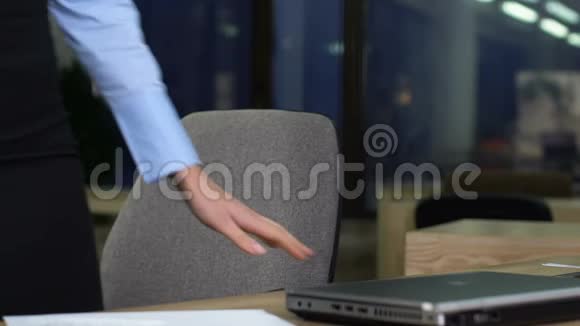 年轻女子穿着正式西装打开笔记本电脑看电子邮件晚上工作视频的预览图