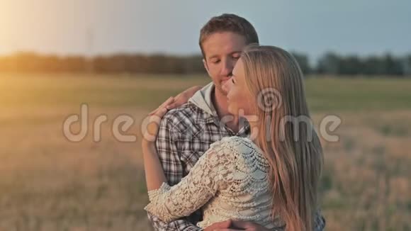 年轻的夫妻在日落时拥抱朝太阳看视频的预览图