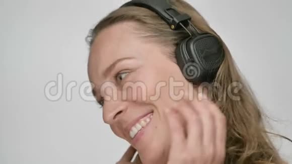 高兴的女人听着她最喜欢的一首关于智能手机跳舞和唱歌的歌一边欣赏音乐的肖像视频的预览图