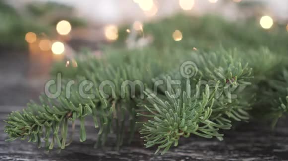 云杉树枝上有美丽的绿针背景上有一个明亮的闪光花环视频的预览图
