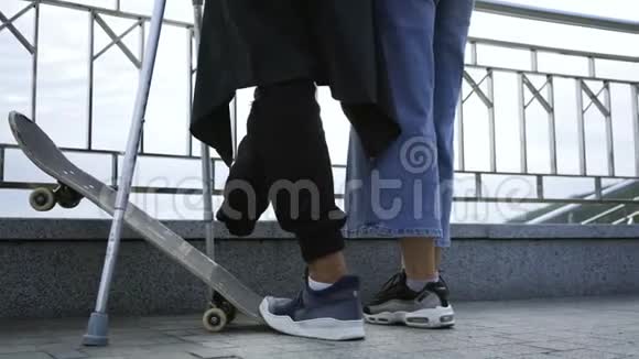 不认识的男人一条腿拐杖滑板在街上和他的女朋友说话积极生活视频的预览图